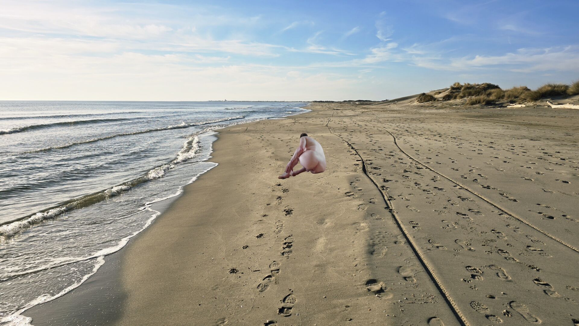 Mer et plage avec homme nu vu de dos.