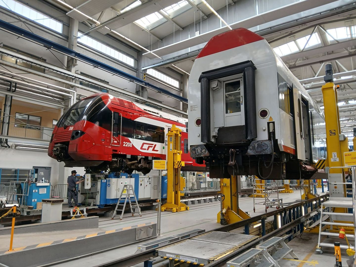 Une voiture DoSto levée et privée des ses bogies, à l'arrière, une automotrice Z 2200