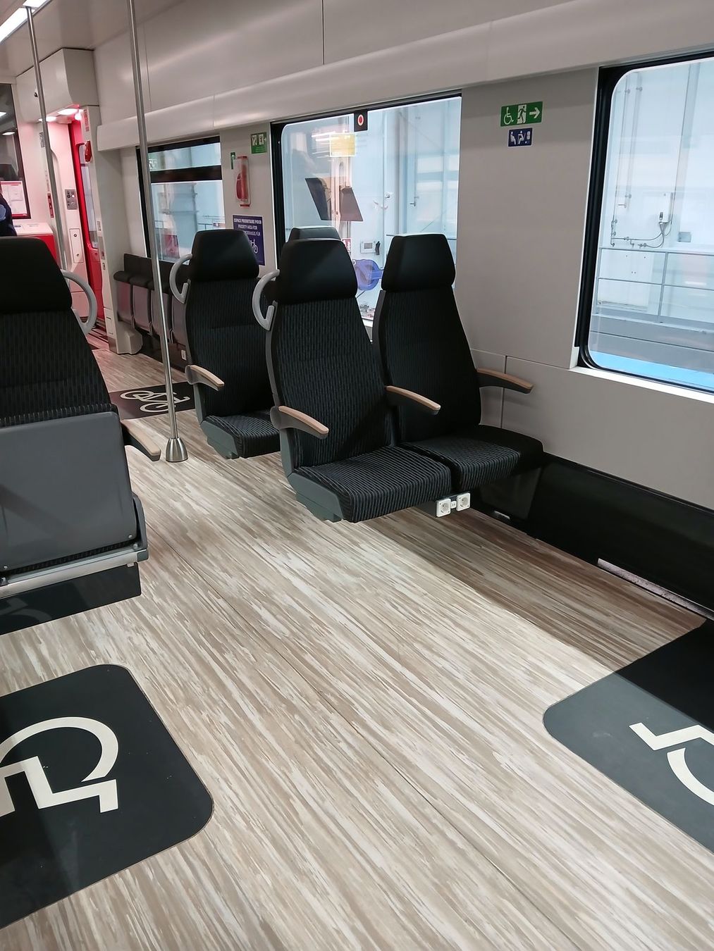 Salle multifonction avec emplacement PMR et poussettes.