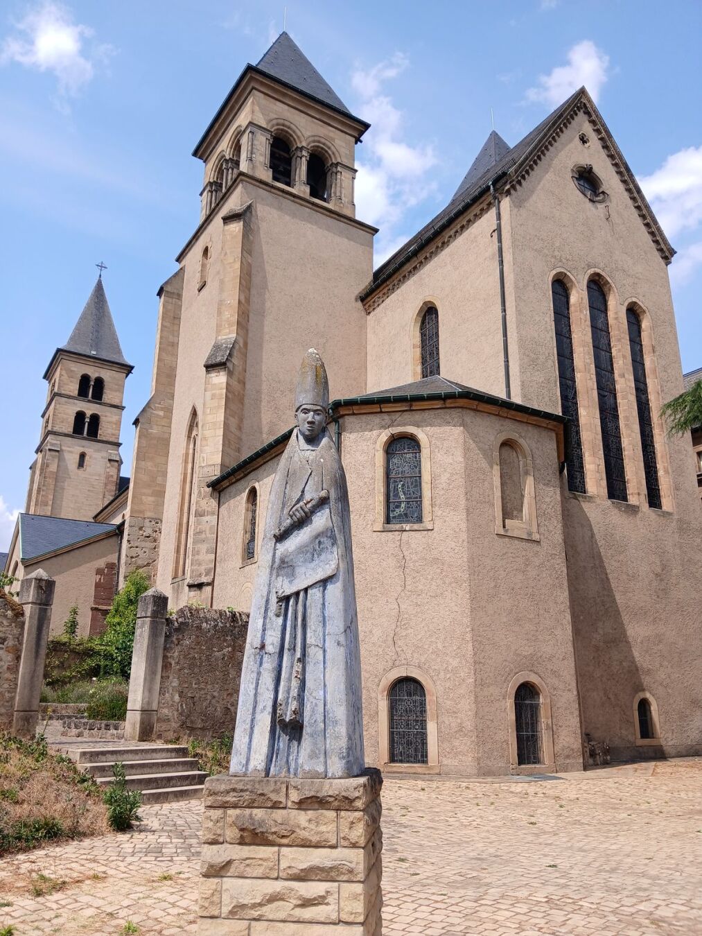 La statue de Saint-Willibrord, le fondateur de l'abbaye d'Echternach à l'arrière de celle-ci.